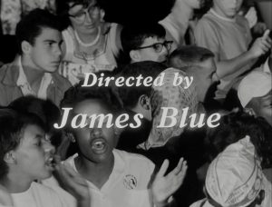 A black and white image shows people clapping and singing. Text is present over the top of the image that says "Directed by James Blue".