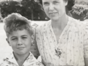 A black and white photo showing James Blue as a child (Left) and his mother (Right). Blue's mother has her arm placed behind his back and both are looking directly into the camera.