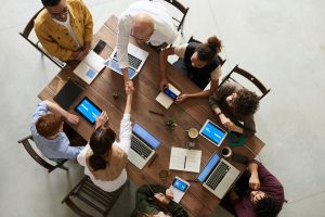 team working together at a table with laptops