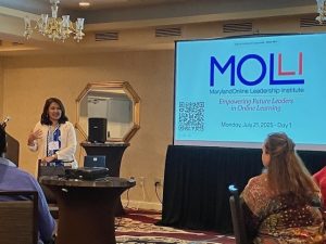 Presenter standing at a podium next to a screen at a professional learning workshop