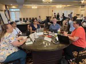 Several higher education faculty and staff members sitting at a table to collaborate during a professional development workshop
