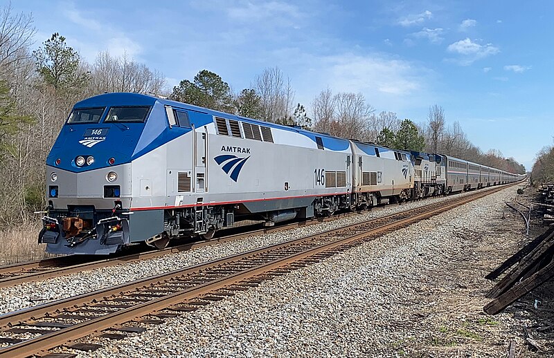 Two train tracks, one empty and an Amtrak train on the other.