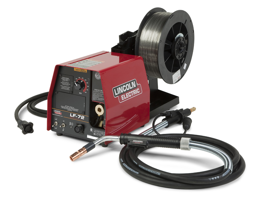 An electric wire feeder. It includes a power cord looped on the left, a spool of wire attached at the back, a welding gun cable and welding gun unattached to the machine on the right.