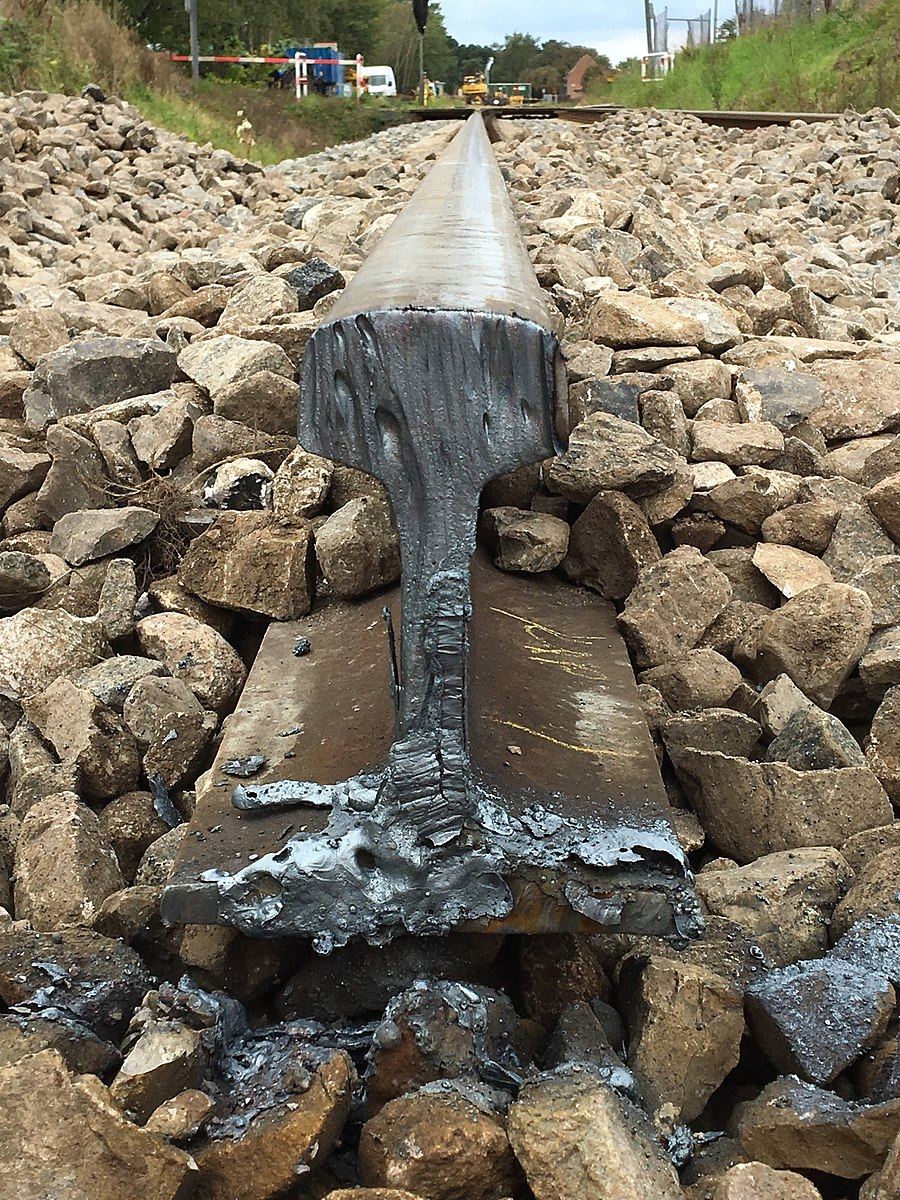 A railroad rail cut on the end with oxy-fuel. The cut shows some melted metal toward the base of the cut, and the edge looks a bit like melted wax on a candle, showing how oxy-fuel cutting heats the metal in order to cut through it.