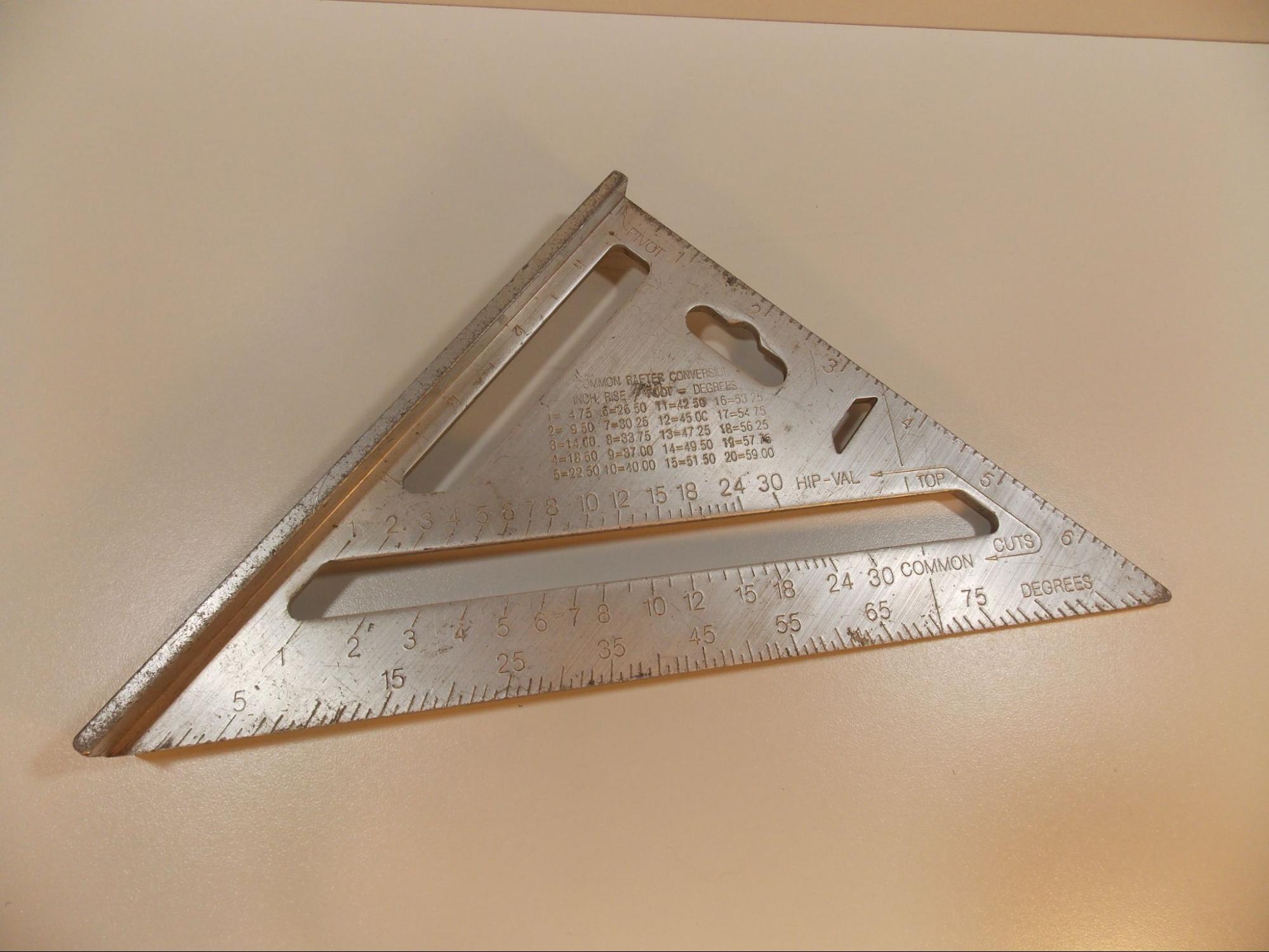 A rafter square, also called a speed square. This square is shaped like a right triangle with a straight reference surface on the base side, a seven inch scale on the height side, and a 0 to 90 degree scale on the hypotenuse side