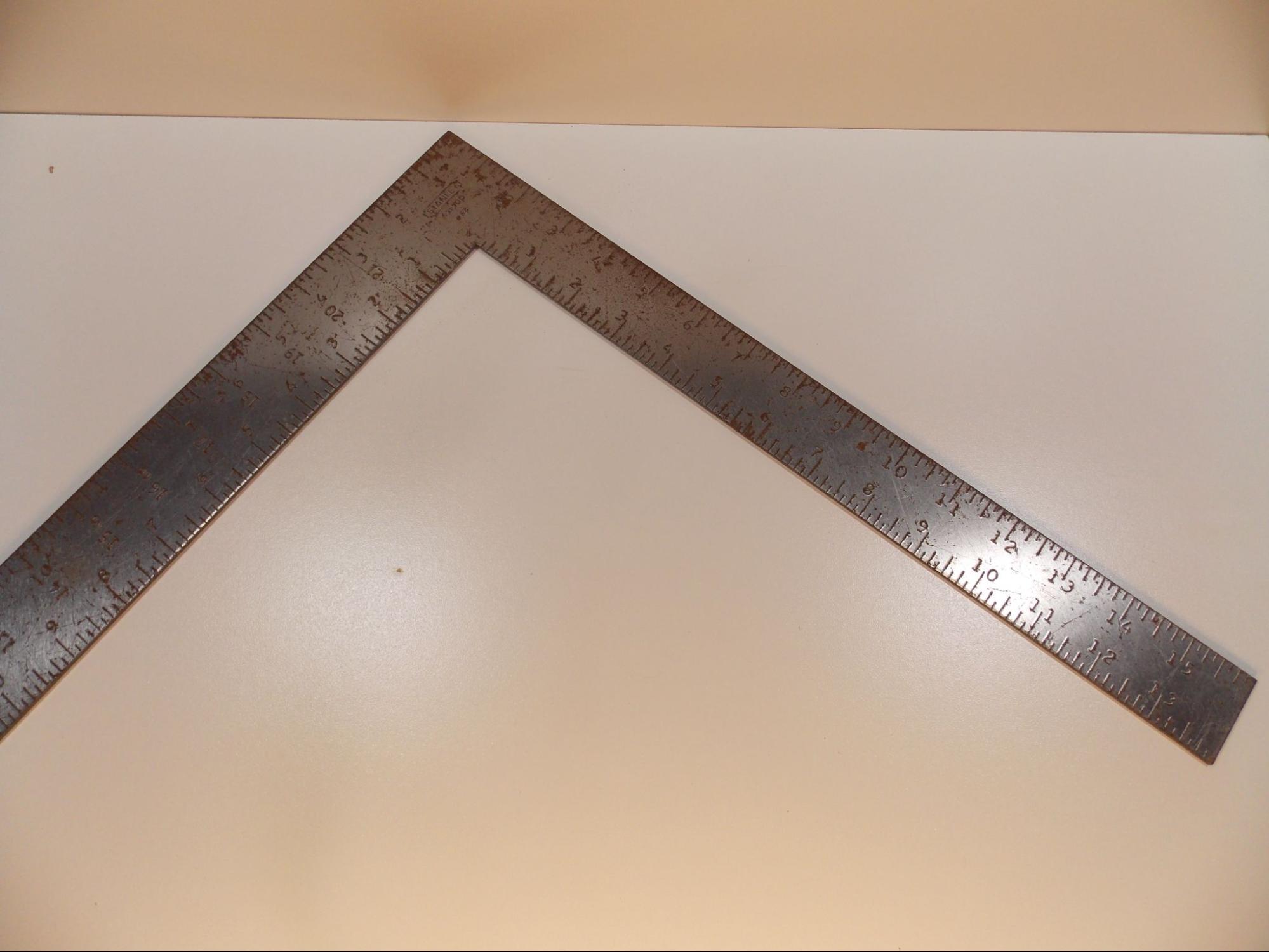 A framing square which looks like two flat metal rulers connected at a right angle.