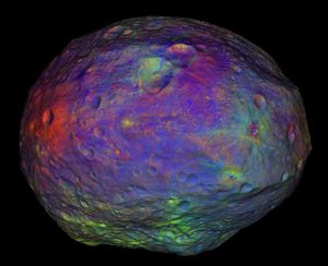 A color map of the asteroid Vesta depicting various mineral deposits. This evidence from Dawn’s visible and infrared mapping spectrometer and gamma ray and neutron detector indicates that there is hydrated material within some rocks on Vesta’s surface, suggesting that Vesta is not entirely dry.