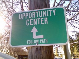 sign that reads &quot;Opportunity Center Follow Path&quot; with an arrow