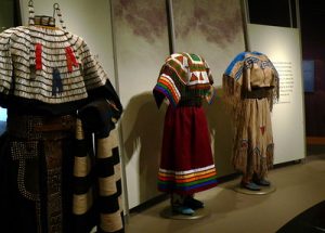 Museum display with three indigenous dresses
