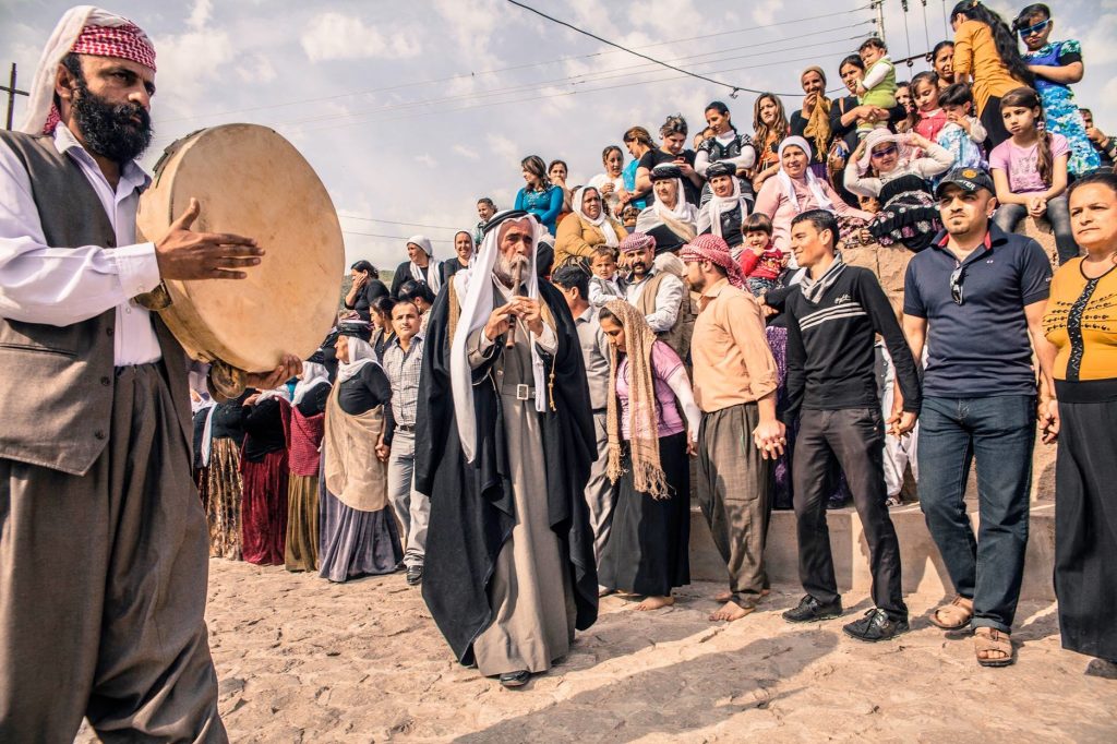 Image of Yazidi Ceremony: 'Sons of the Peacock Angel‘ ​ ​ Prayers and ceremonies during the annual spring celebrations dedicated to the shrine of Mohamed Rashan where many Yazidi's families, each from different villages, pay their visit to the servant of the temple and his family offering him food and donations. This is one of the most important celebrations of Yazidis. They camp together in wide grass fields, pray and dance typical music played by the Kawals using the 2 typical instruments, the Daf (frame drum) and the Shabbabi (flute).” Caption and image by Giulio Paletta, LUZ Photography, All rights reserved.