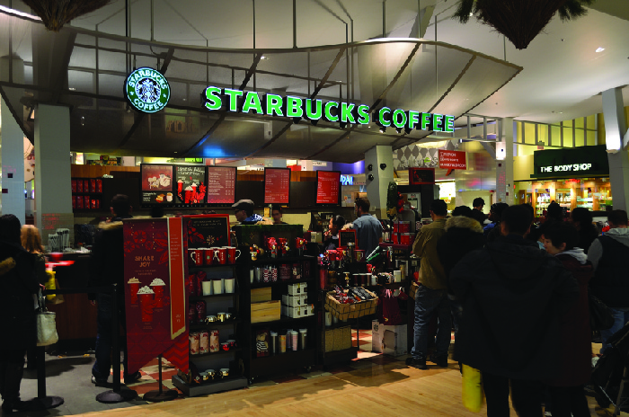 A picture of the inside of a Starbucks store showing shelves of items for sale.
