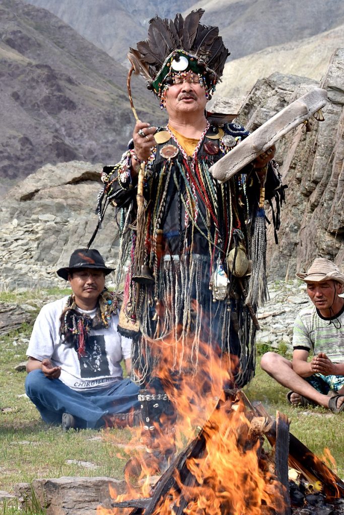 Tuvan shaman performing Mongush Lazo shamanic ritual 'Ovaa' in front of a fire in the mountains