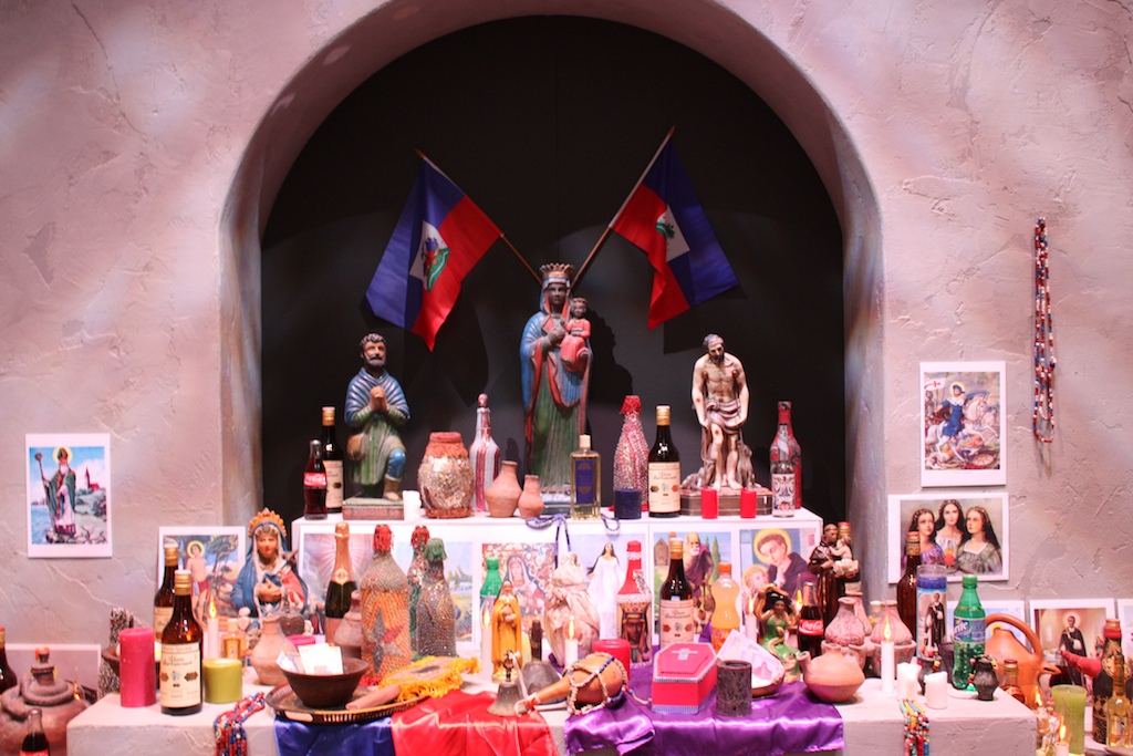 Altar of Vodou loas in Tropenmuseum, containing statues of the various loas, objects and images associated with each loa