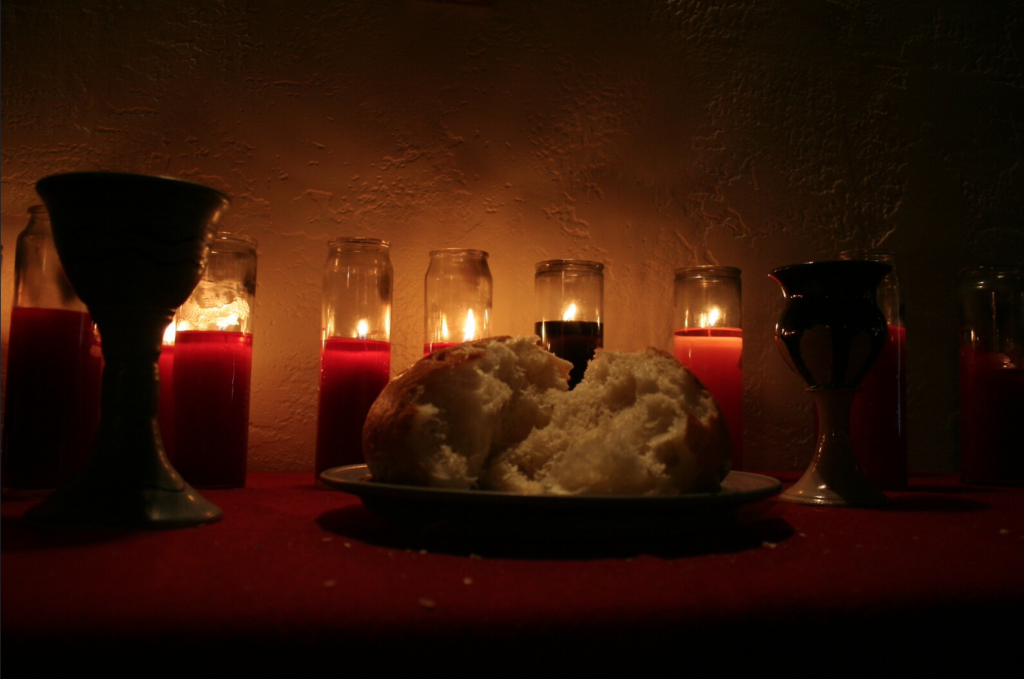 Candles, wine glasses and bread in a religious setup